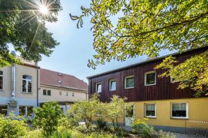 a building with a wooden facade next to two buildings at Gästezimmer - Meißen in Meißen