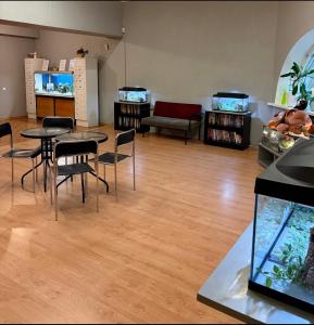 a living room with tables and chairs and an aquarium at Narva Center Aparthotel in Narva +13 photos