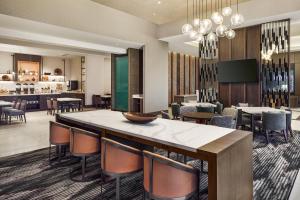 a hotel lobby with a large table and chairs at Apiary Hotel Belleview Station Denver in Denver