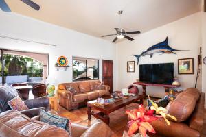 a living room with leather furniture and a fish on the wall at Pool Oasis Close to the Beach and Pickleball in Las Palmas
