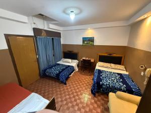 a hotel room with two beds and a table at Hispano Argentino in Buenos Aires