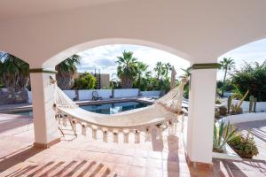 a hammock on a patio next to a pool at Pool Oasis Close to the Beach and Pickleball in Las Palmas