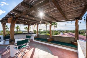 a patio with a wooden pergola and a table and chairs at Pool Oasis Close to the Beach and Pickleball in Las Palmas