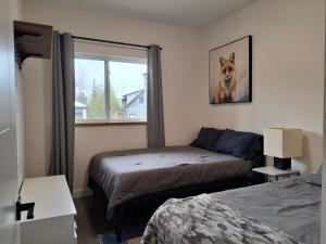 a bedroom with two beds and a dog picture on the wall at Fernie Alpine Retreat in Fernie