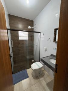 a bathroom with a shower and a toilet and a sink at Pousada Os Galeguinhos in Santa Cruz do Rio Pardo +30 photos