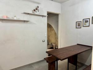 a dining room with a wooden table and a wall at Residenza 33 in Torchiara