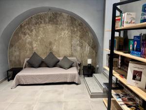 a bedroom with a bed with a stone wall at Residenza 33 in Torchiara