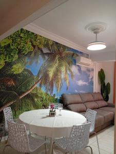 a living room with a table and a palm tree mural at Alma Brizo Suites in Grao de Castellón