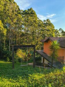 a playground in a yard next to a house at Pousada Vale do Horizonte in Monte Verde