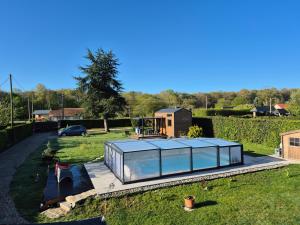 a glass house in the middle of a yard at l'escale de Normandie in Saint-Martin-au-Bosc