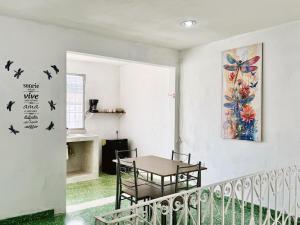 a dining room with a table and birds on the wall at Casona Tulish, Campeche in Campeche