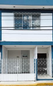 a blue and white building with a white gate at Casona Tulish, Campeche in Campeche