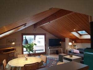 a living room with a table and a couch at Chalet Himmelblick in Dornbirn