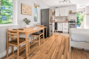 a kitchen and dining room with a wooden table and chairs at Rising Tide- Cabin In Ucluelet in Ucluelet