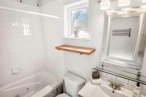 a bathroom with a toilet and a sink and a mirror at Rising Tide- Cabin In Ucluelet in Ucluelet +19 photos