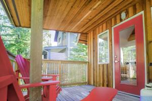 a porch with red chairs and a red door at Rising Tide- Cabin In Ucluelet in Ucluelet