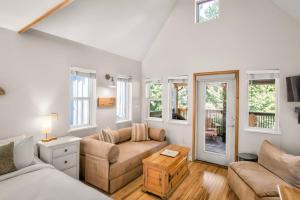 a living room with a couch and a table at Rising Tide- Cabin In Ucluelet in Ucluelet