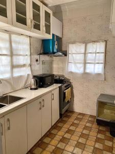 a small kitchen with white cabinets and a stove at Executive Delight Suites and Apartments in Magboro-Akeran