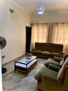a living room with a couch and a coffee table at Executive Delight Suites and Apartments in Magboro-Akeran