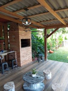 a patio with a stone fireplace and a table and stools at Cantinho do Sossego in Prudentópolis