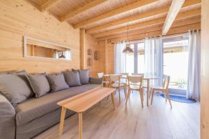a living room with a couch and a table at Domki Między Sosnami in Pobierowo