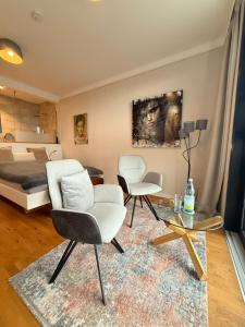 a living room with two chairs and a bed at Huus Bellevue in Gleisweiler