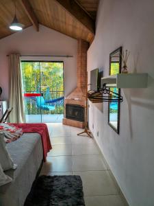a living room with a bed and a fireplace at Pousada Vale do Horizonte in Monte Verde