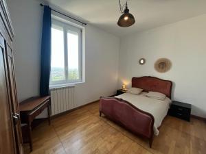 a bedroom with a bed and a desk and a window at Maison avec piscine et vue panoramique in Albi +14 photos