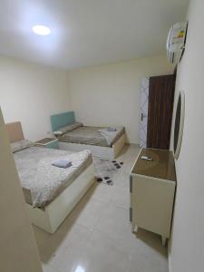 a room with three beds and a refrigerator at Tiba Golden beach resort hurghada down town in Hurghada +20 photos