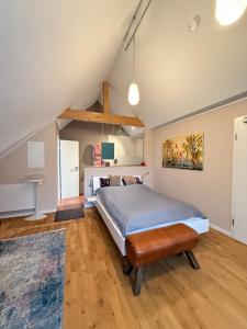 a bedroom with a bed and a wooden floor at Huus Bellevue in Gleisweiler