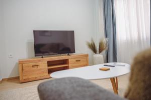 a living room with a tv and a white table at Datidis Urban Nest in Komotini