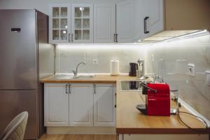 a kitchen with white cabinets and a red appliance at Datidis Urban Nest in Komotini +11 photos