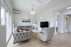 a living room with a couch and a tv at Lumina Residence in Sarajevo