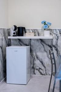 a white refrigerator in front of a wall with shelves at Palazzo Ambrosio in Nola +11 photos