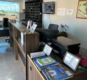 an office with a desk with a computer on it at Pousada Os Galeguinhos in Santa Cruz do Rio Pardo