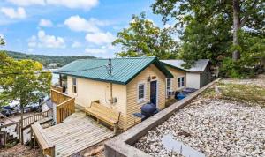 a tiny house with a wooden porch and a deck at The Rubber Duck in Gravois Mills