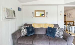 a living room with a brown couch with pillows at The Rubber Duck in Gravois Mills