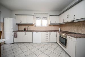 a kitchen with white cabinets and a white refrigerator at Mikuljan Apartments with Pool-5 min to Beach & Private Parking Included in Stobreč