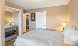 a bedroom with a white bed and a mirror at Amber Waters Hideaway in Camdenton