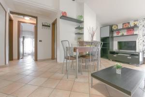 a living room with a table and chairs and a television at Queen Home Funo Centergross in Castel Maggiore