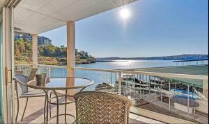 a balcony with a table and chairs and a view of the water at Waters Edge in Lake Ozark