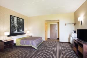 a hotel room with a bed and a flat screen tv at Super 8 by Wyndham Plattsburgh in Plattsburgh