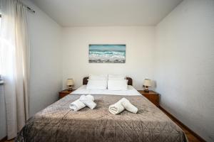 a bedroom with a bed with two towels on it at Mikuljan Apartments with Pool-5 min to Beach & Private Parking Included in Stobreč +44 photos