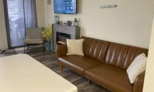 a brown couch in a living room with a fireplace at The Luxe Lakefront in Lake Ozark
