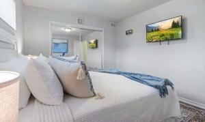 a bedroom with a white bed with white pillows at The Luxe Lakefront in Lake Ozark