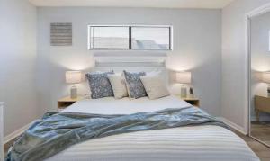 a white bedroom with a large bed with pillows at The Luxe Lakefront in Lake Ozark +41 photos
