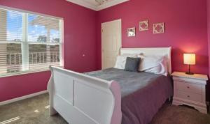 a bedroom with pink walls and a bed and a window at Lakeside Lookout in Sunrise Beach