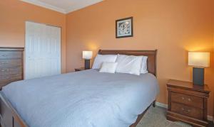 a bedroom with a large bed with two night stands and two lamps at Lakeside Lookout in Sunrise Beach