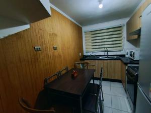 a kitchen with a wooden table with chairs and a sink at Tronador I in Puerto Montt