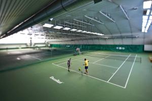 two men standing on a tennis court at Hotel Włókniarz in Pabianice